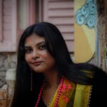 Young woman in a colorful saree with traditional accessories in Kolkata, India.